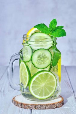 Glass with fresh organic detox cucumber water with lime and lemon.