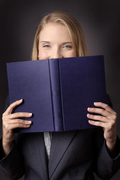 Boek in de buurt van haar gezicht — Stockfoto