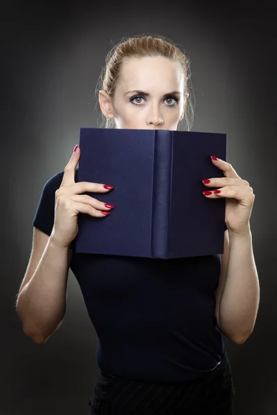 Mädchen versteckt sich hinter dem Buch — Stockfoto