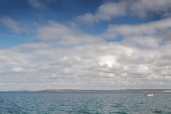 Білі пухнасті хмари біля моря — стокове фото