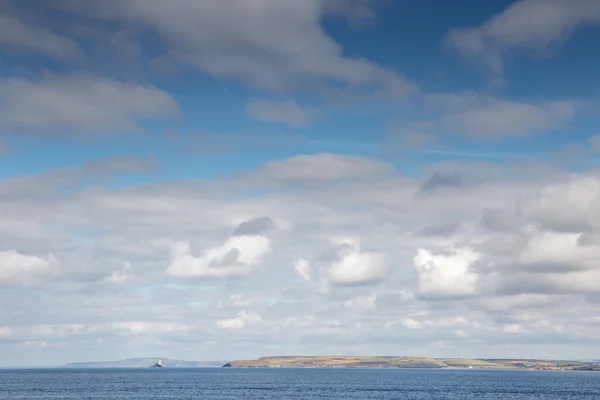 Witte pluizige wolken neer door de zee — Stockfoto