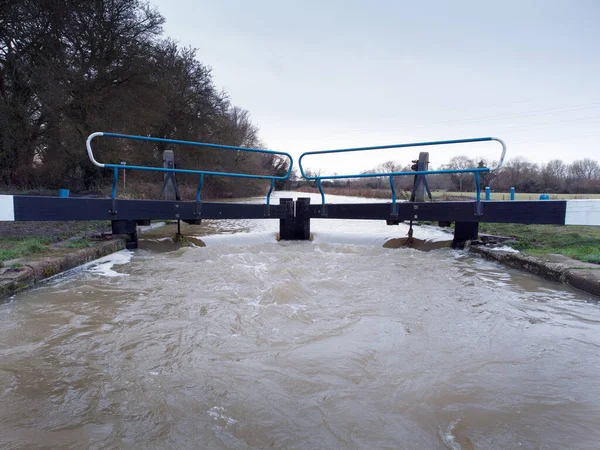 high water overflowing over a lock in essex englang after a lot of rainfall