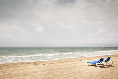 İspanya 'da sahilde güneşlenen iki kişi. Etrafta kimse yok.  