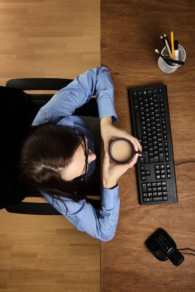 Kvinna som arbetar vid skrivbord skott från ovan — Stockfoto