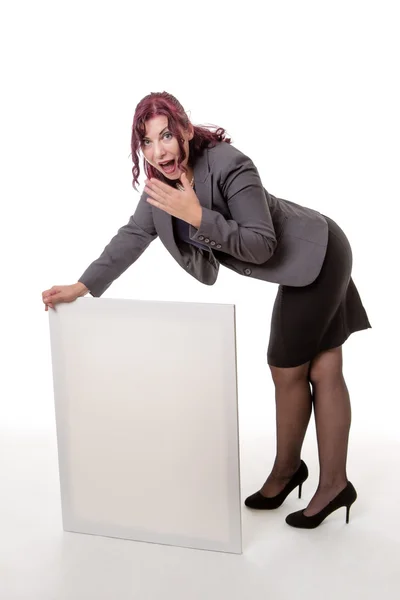 Woman leaning on a blank sign with her hands against a white bac — Stock Photo, Image