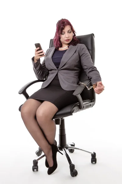 Woman handcuffed to office chair — Stock Photo, Image