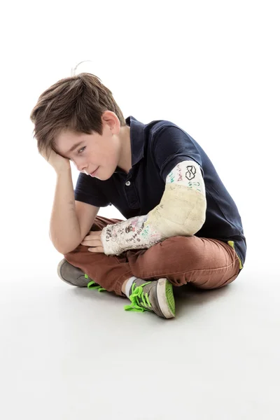 Ledsen pojke med bruten arm — Stockfoto