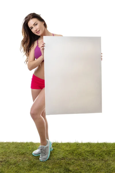 Mujer fitness sosteniendo gran signo de papel en blanco . — Foto de Stock