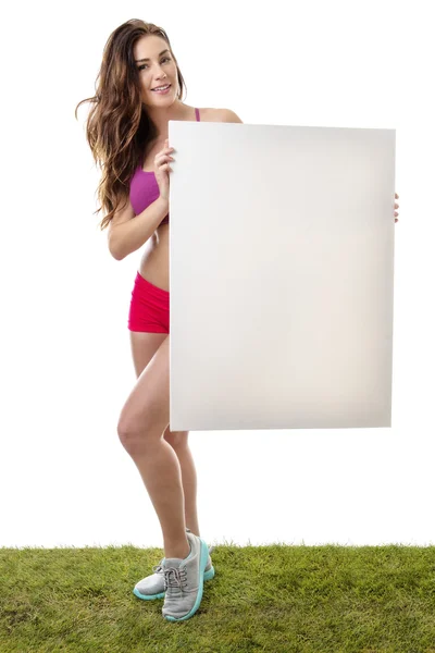 Mujer fitness sosteniendo gran signo de papel en blanco . — Foto de Stock