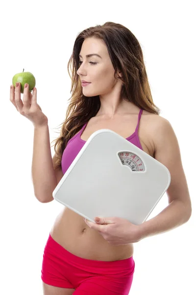 Mulher saudável com uma maçã e escamas . — Fotografia de Stock