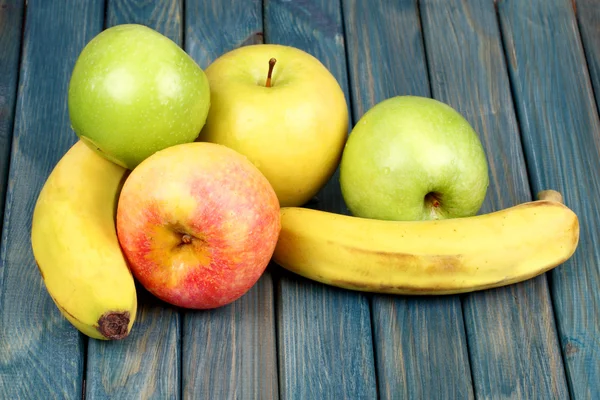 Бананы и яблоки на деревянном столе — стоковое фото