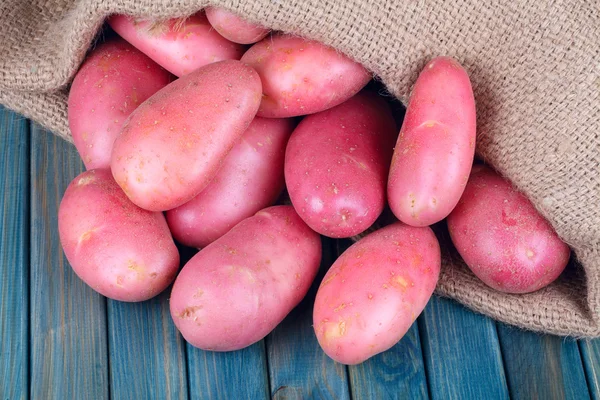 Rode aardappelen op een blauwe houten tafel — Stockfoto
