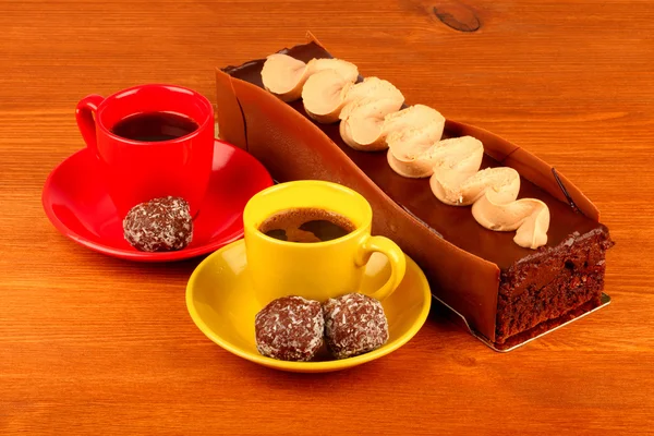 Chocolate cake with two cup of coffee and chocolate balls on woo — Stock Photo, Image