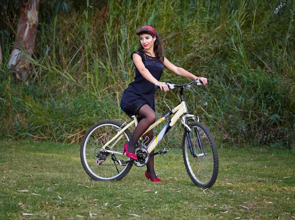 Brunette woman modeling on a bike — Stock Photo, Image