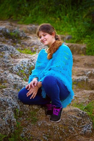 Girl sitting on stone — Stock Photo, Image