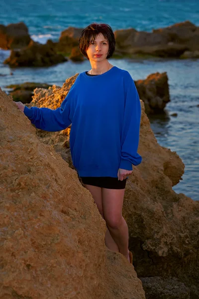 Junge Frau auf einem Felsen am Meer — Stockfoto