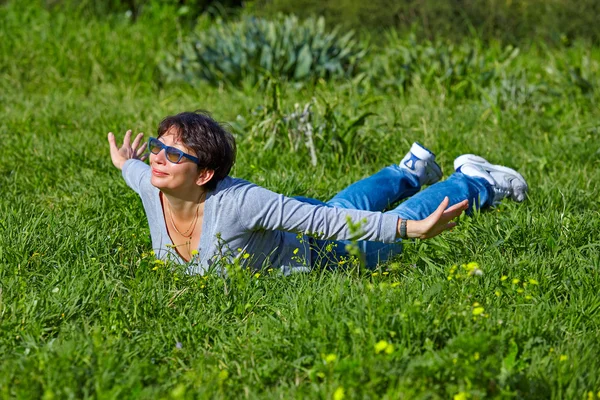 Frau liegt auf grünem Gras — Stockfoto