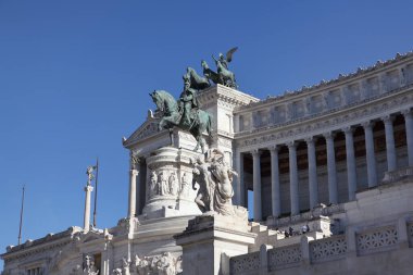 Roma, İtalya - 21 Eylül 2025: Roma 'daki beyaz mermer Altare della Patria' nın (Victor Emmanuel II Anıtı), klasik mimarisi, sütunları ve bronz savaş arabası heykellerini (kuadrigae) parlak mavi gökyüzü karşısında sergiliyor..