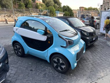 Roma, İtalya - 17 Eylül 2025: Modern açık mavi XEV Yoyo elektrikli mikroarabası Roma, İtalya 'da bir kaldırım taşı caddesinde park halinde. Sürdürülebilir kentsel hareketlilik ve kompakt çevre dostu şehir taşımacılığı kavramı.