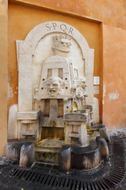 Roma, İtalya - 17 Eylül 2025: Fontana degli Artisti (1927), Roma Taş çeşme iki sanatçının sehpalarını temsil ediyor. Tuhaf maskeler ve S P Q R yazıtlarıyla..