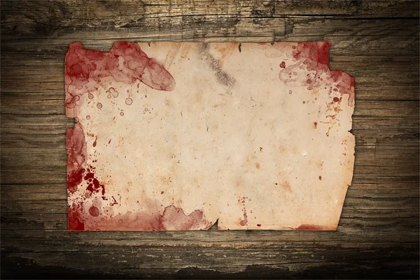 Väderbitna papper med blod fläckar på en trä bakgrund — Stockfoto
