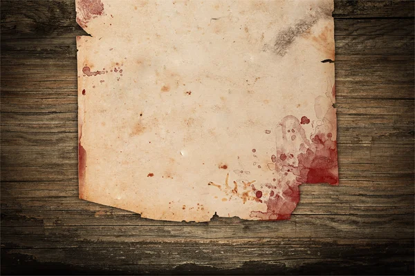 Ahşap arka plan üzerinde kan lekeleri ile yaşlı kağıt — Stok fotoğraf