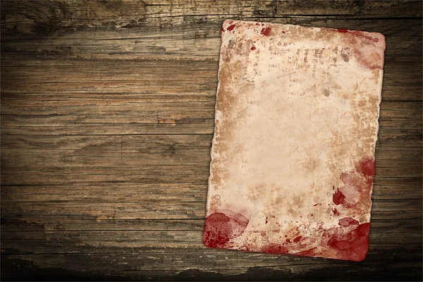 Verweerde papier vel met bloed vlekken op hout — Stockfoto
