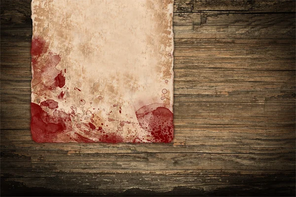 Papel enrugado coberto de sangue sobre madeira — Fotografia de Stock
