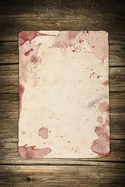 Papel envejecido con manchas de sangre sobre un fondo de madera oscura — Foto de Stock