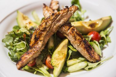 Izgara tavuk tenderloins avokado ve sebze salatası.