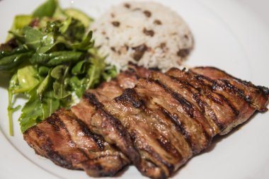 Pirinç ve yaprak yeşil salata ızgara biftek