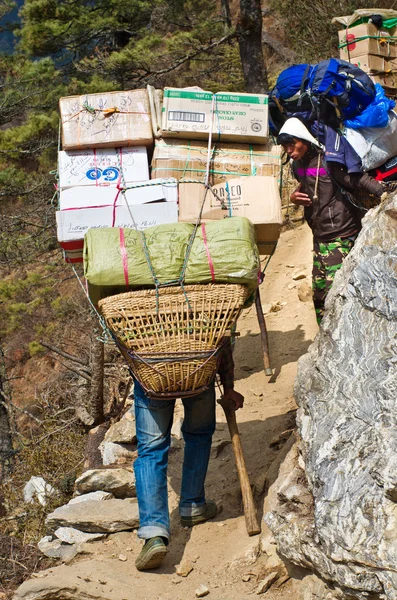 Porters carry heavy load in Himalaya — Stock Photo, Image