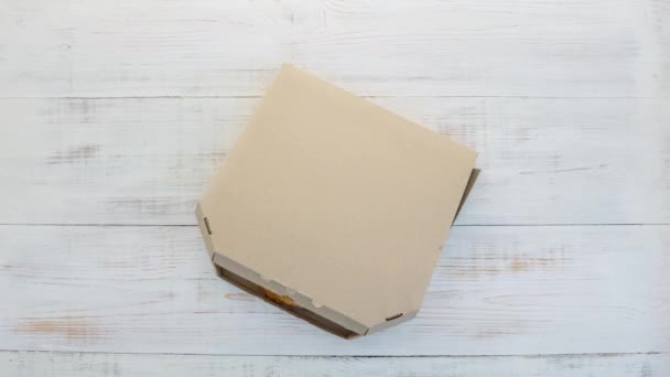 Otwarcie pudełka po pizzy na białym drewnianym tle, zatrzymanie ruchu — Wideo stockowe