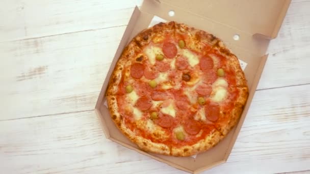 Abrindo uma caixa de pizza no fundo de madeira branco — Vídeo de Stock