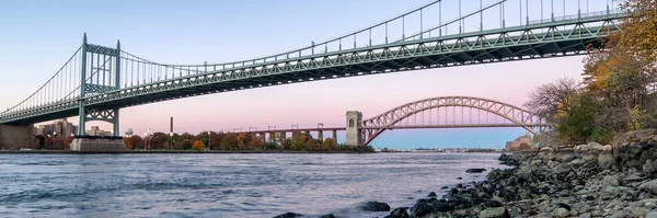 Panoramic view of Hell Gate Bridge and Triborough Bridge at night, in Astoria, Queens, New York. USA