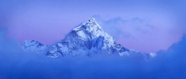 Snow mountain against a blue sky clipart