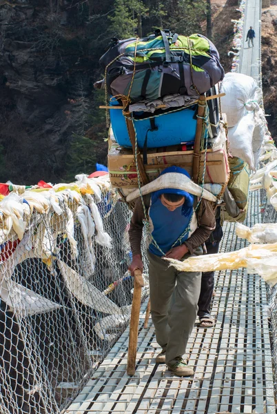 Porters carry heavy load — Stock Photo, Image