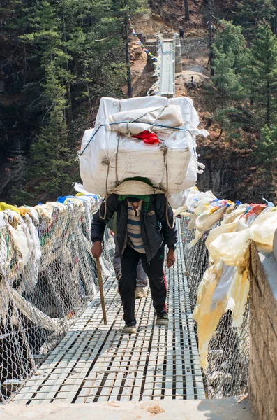 Porters voeren zware belasting in de himalaya — Stockfoto