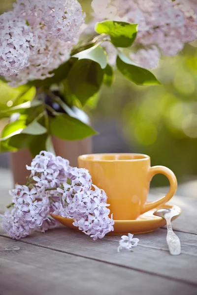 Bouquet de lilas et tasse avec une cuillère — Photo