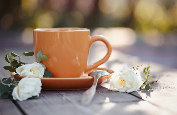 Tasse orange avec une cuillère et г © glantier blanc — Photo