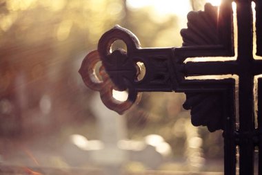 Mezarlıktaki mezarlık haçının bir parçası. Güneşi kapatan kirişler içinde..