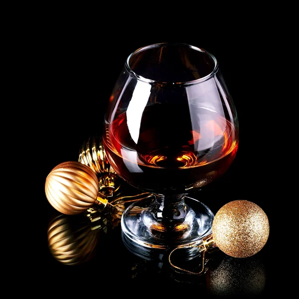 Glass with drink and a Christmas balls. — Stock Photo, Image