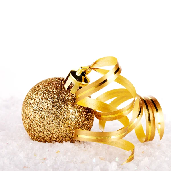 Новогодний золотой шар на снегу с лентой . — стоковое фото