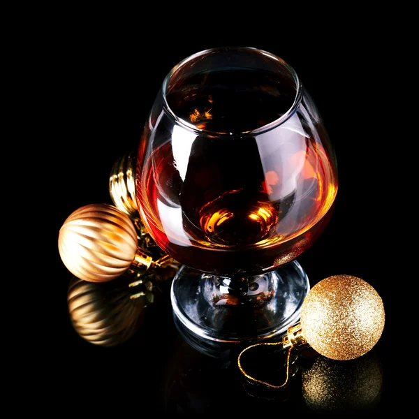 Glass with drink and a Christmas balls. — Stock Photo, Image