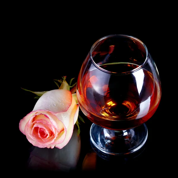 Glass with alcohol and rose. — Stock Photo, Image