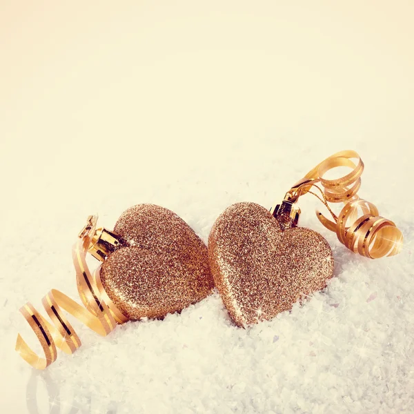 Zwei Herzen mit Goldbändern auf Schnee — Stockfoto
