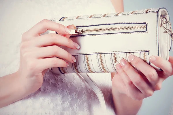 Manos femeninas con manicura con pequeño bolso blanco — Foto de Stock
