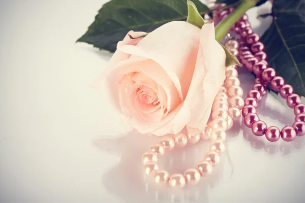 Pink rose and pearl beads. — Stock Photo, Image