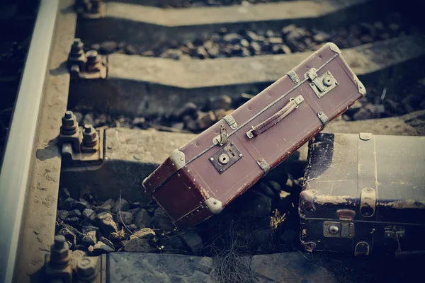 Old vintage suitcases forgotten lie on railway rails. — Stock Photo, Image