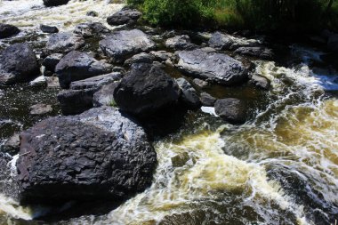 Dağ nehrinde büyük kaya parçaları var.
